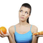 woman choosing between pizza and orange